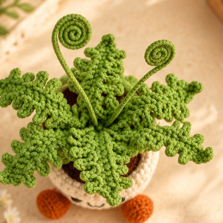Collage showing a green crochet fern with curled stems in a smiling cream pot with orange feet