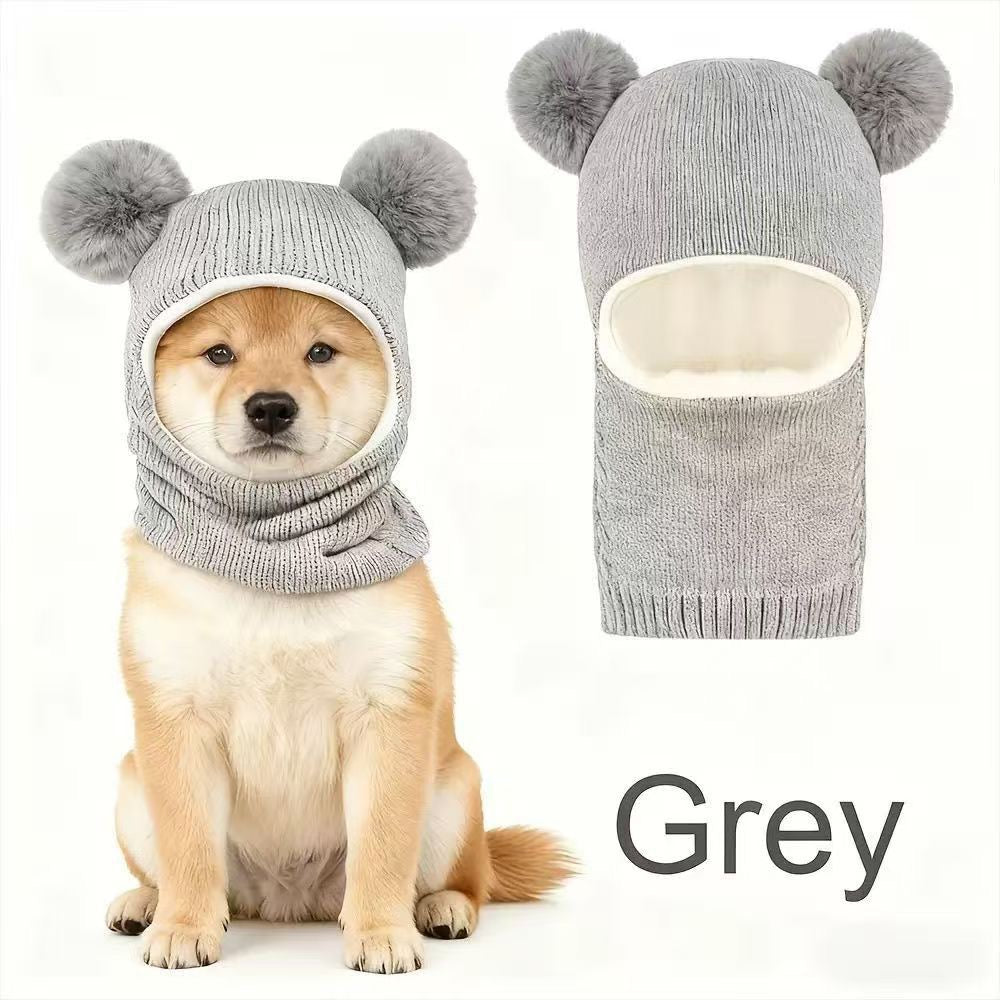 Grey knitted dog hood with double pom-poms, shown on a dog and separately