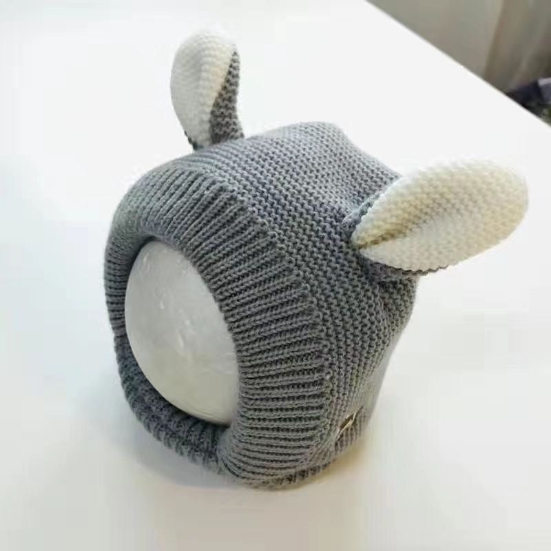 Black knitted dog hood with contrasting cream animal ears.