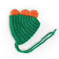 Green handmade knitted dinosaur dog hat with orange spikes and green chin ties.