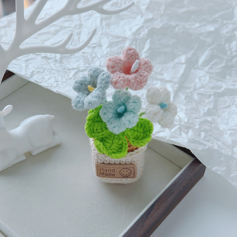Two-tone blue crochet bouquet in a tan pot.