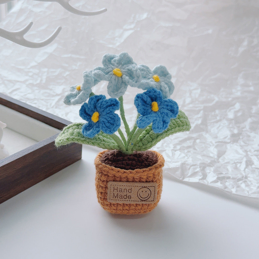 Mixed pink orange white and blue crochet flowers.