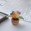Yellow crochet sunflower in a miniature cream pot.