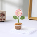 Pastel mixed crochet flowers in a miniature cream pot.