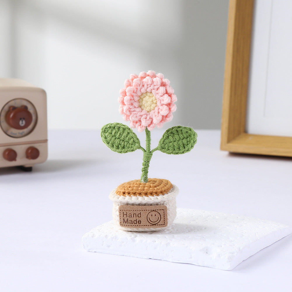 Pastel mixed crochet flowers in a miniature cream pot.