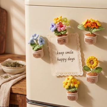 Crochet potted flower fridge magnets arranged around a keep smile happy days note.